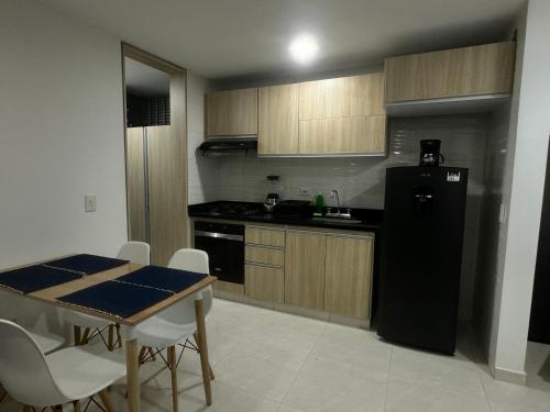 cocina con nevera negra y mesa en Apartamento Ibagué La Samaria Mirolindo, en Ibagué