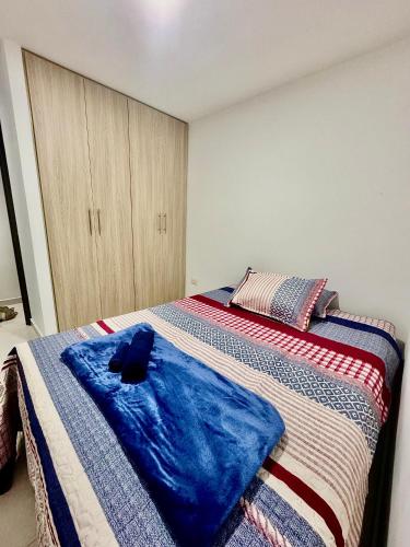 a bedroom with a bed with a blue blanket at Apartamento Ibagué La Samaria Mirolindo in Ibagué