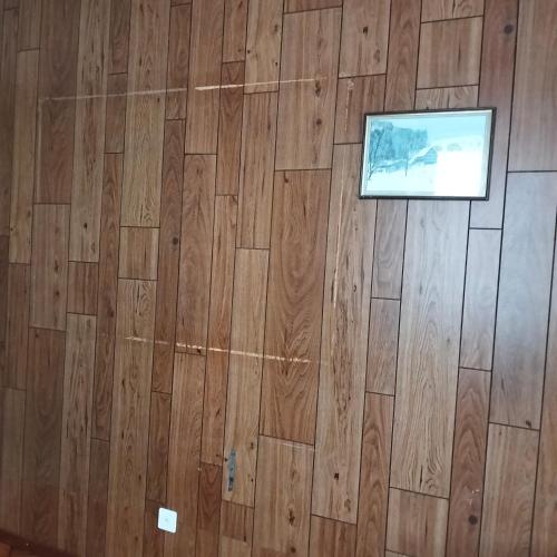 a room with a wooden floor with a picture on it at Guest room in Couvet