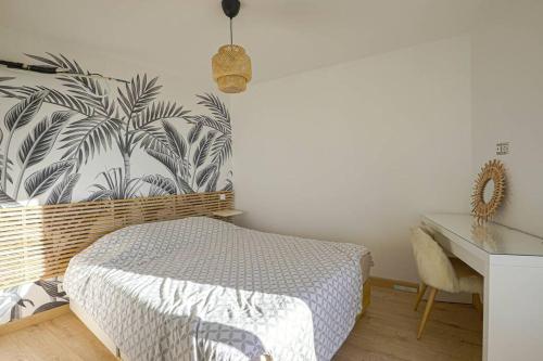 a bedroom with a bed and a desk and a wall at Charmante petite maison de ville avec balcon in Fréjus