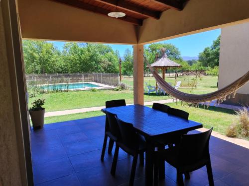 a patio with a blue table and chairs and a hammock at Complejo Boulevard in Villa Ciudad de America