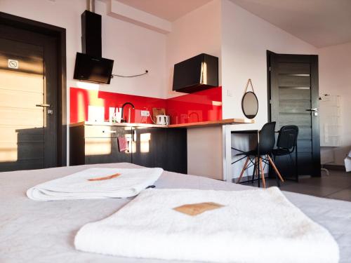 a bedroom with a white bed and a kitchen at Orange Tree Hotel in Będzin
