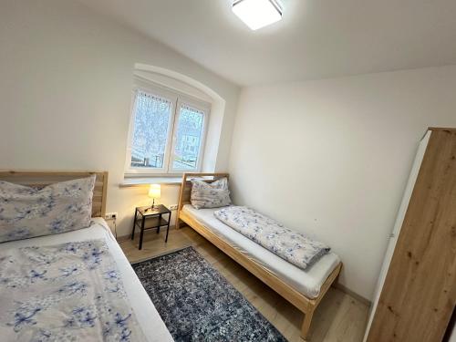 Habitación pequeña con 2 camas y ventana en Ferienwohnung Niederthalheim, 