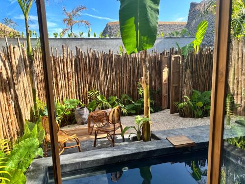 a garden with two chairs and a fence at Be Zanzibar Boutique Hotel in Mfumbwi