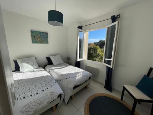 2 Betten in einem Zimmer mit Fenster in der Unterkunft La maison d'Amélie, Villa climatisée piscine privée 4 Chambres, 3 sdb in Mazan