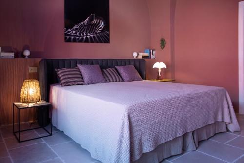 a bedroom with a large bed with purple walls at Antica Masseria le Monache in Grottaglie