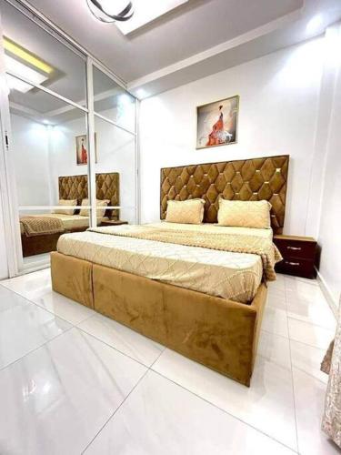 ein Schlafzimmer mit einem großen Bett und einem Spiegel in der Unterkunft Spacieux duplex à louer à Dakar in Dakar