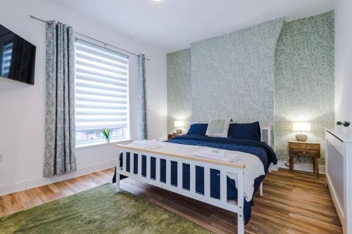 a bedroom with a blue and white bed and a window at 4 Bedroom Victorian House in Manchester