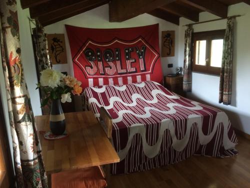 - une chambre dotée d'un grand lit avec un couvre-lit rouge et blanc dans l'établissement Casa del Sole Borgo Prediera, 