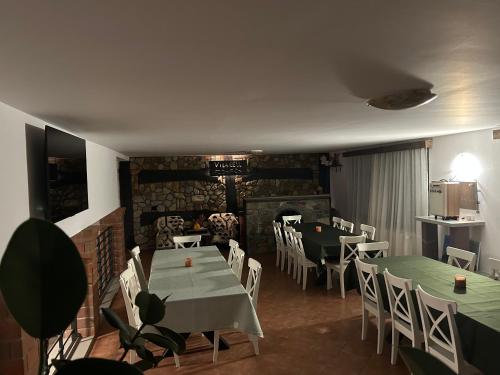 a restaurant with tables and chairs and a fireplace at Vila Eell in Borsa