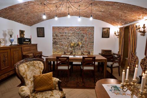 een eetkamer met een tafel en een bakstenen muur bij Casa Ceauș in Baia-Sprie