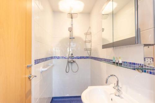uma casa de banho com um chuveiro e um lavatório. em The Portwey Pearl em Rodwell