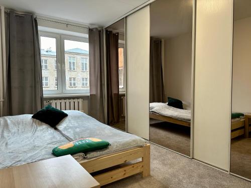 a bedroom with a bed and a large mirror at Apartament Stadion - duży apartament blisko Stadionu Narodowego w Warszawie. in Warsaw