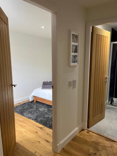 a room with a door and a bedroom with a bed at Tiny House in Cosy Village in Milnathort