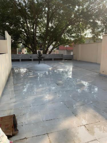 a concrete patio with a tree in the background at Hostal YOA 101 in Mexico City