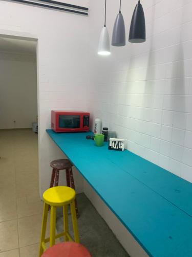 cocina con encimera azul y 2 taburetes en Hostal YOA 101, en Ciudad de México