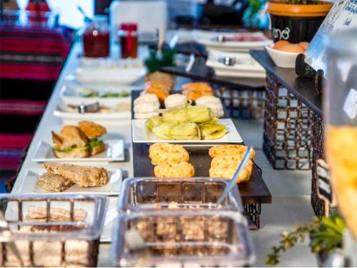 una línea de buffet con diferentes tipos de comida en platos en Altus Express Hotel en La Paz