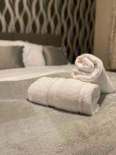 una pila de toallas blancas en una cama en Spacious 4-bed House in Leicester, en Leicester
