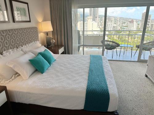 a bedroom with a bed with a view of a balcony at Blue Paradise Suite Free Parking in Honolulu
