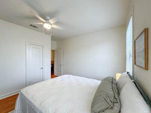 a white bedroom with a bed and a ceiling fan at New Comfy Bungalow on Washington-Dedicated Office in Waco