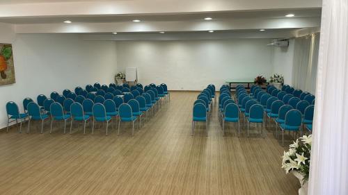 a room with blue chairs and a podium in a room at Serrambi Resort in Porto De Galinhas