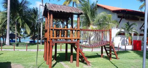a wooden playground with a swing at Serrambi Resort in Porto De Galinhas