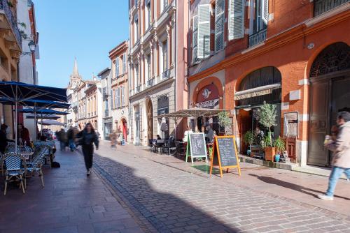 a group of people walking down a street with buildings at T1 bis Hyper centre historique, 100m Capitole in Toulouse