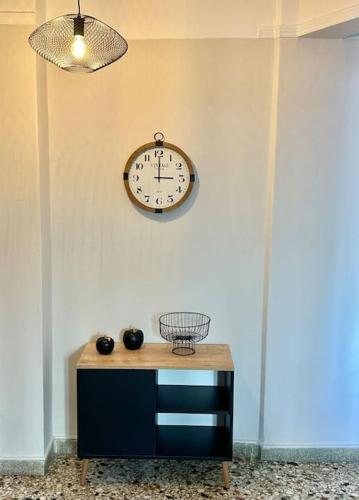 a clock hanging on a wall next to a table at Central House in Plaka in Athens
