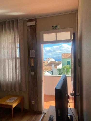 a room with a door open to a balcony at Apartamentos São João in Horta
