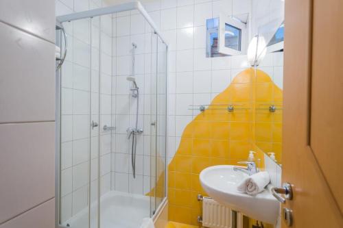 a bathroom with a shower and a sink with a giant shower head at Jade Panzio in Balatonföldvár