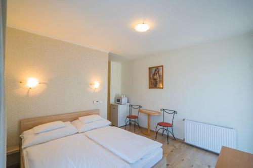 a bedroom with a bed and a table and chairs at Jade Panzio in Balatonföldvár