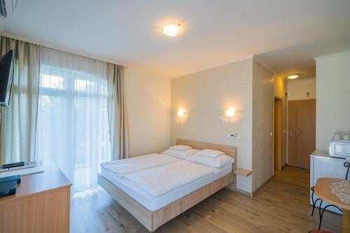 a bedroom with a bed and a large window at Jade Panzio in Balatonföldvár