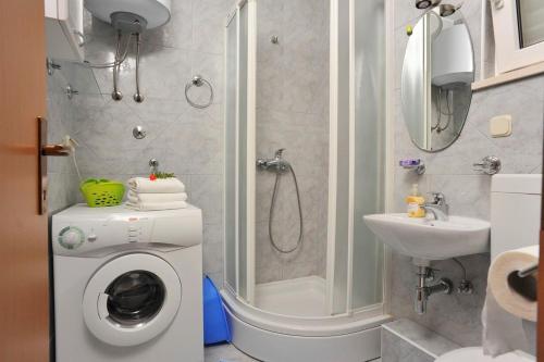 a bathroom with a washing machine and a shower at Apartment Mariner in Sutivan