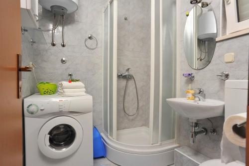 ein Badezimmer mit Waschmaschine und Dusche in der Unterkunft Apartment Mariner in Sutivan