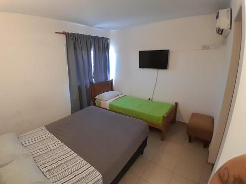 a hotel room with two beds and a television at Hotel CBA in Cordoba