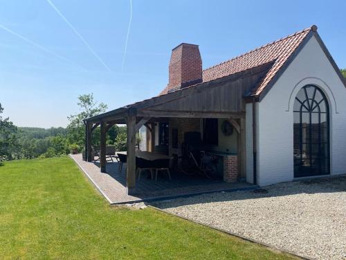 a small white building with a picnic table in front of it at Gastenverblijf A&A met mezzanine in Gavere