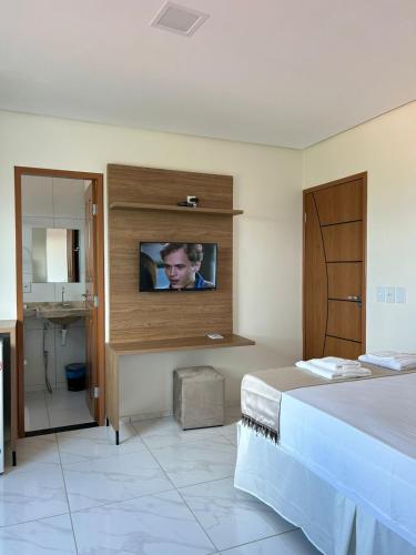 a bedroom with a bed and a tv on a wall at Hotel Carvalho in Ibiapina