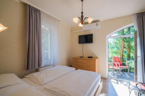 1 dormitorio con 1 cama y ventana con patio en Jade Panzio, en Balatonföldvár