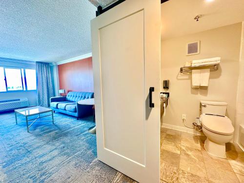 a bathroom with a toilet and a living room at Lincoln Hotel Monterey Park Los Angeles in Monterey Park
