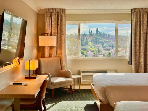 a hotel room with a bed and a desk and a window at Lincoln Hotel Monterey Park Los Angeles in Monterey Park