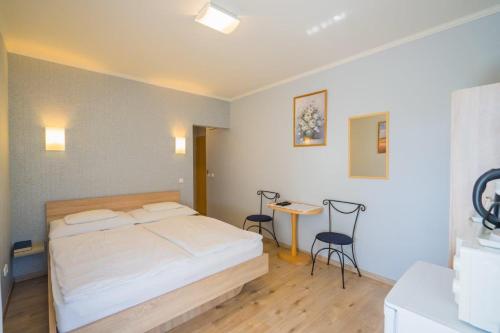 a bedroom with a bed and a table and chairs at Jade Panzio in Balatonföldvár