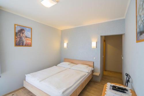a bedroom with a large bed with white sheets at Jade Panzio in Balatonföldvár