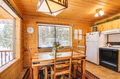 a dining room with a table and a refrigerator at Duck Creek Village Cozy Cabin Near Fishing and ATV in Duck Creek Village