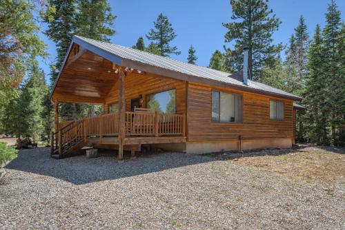 a log cabin with a large porch and a deck at Duck Creek Village Cozy Cabin Near Fishing and ATV in Duck Creek Village