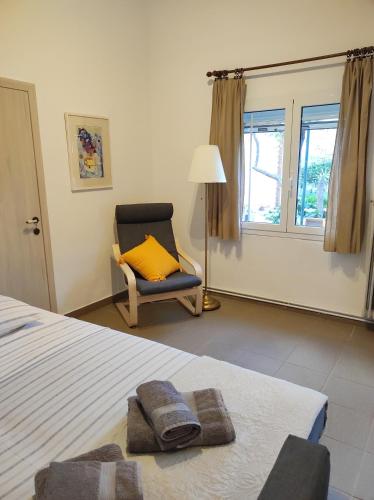a bedroom with a bed and a chair with a yellow pillow at Nicola's House in Myrina