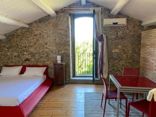 1 dormitorio con cama, mesa y ventana en Il Casale en Marano Marchesato