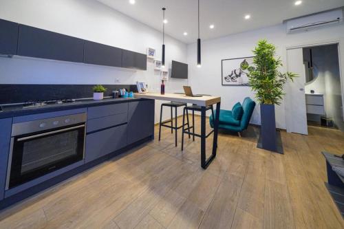 cocina con encimera y mesa con planta en Run House 07 Rooms & Apartments, en Cassano delle Murge