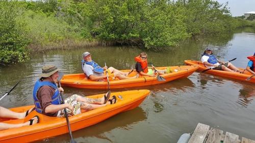 a group of people in kayaks on the water at The Beach House at Si Como No Inn in Flagler Beach