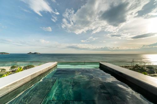a swimming pool with a view of the ocean at Lifestyle Laghetto Collection in Rio de Janeiro