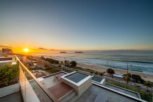 a view of the beach at sunset from a building at Lifestyle Laghetto Collection in Rio de Janeiro